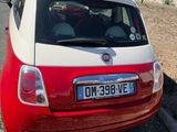 a small red and white car parked on the side of the road