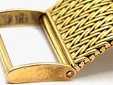 a close up of a gold belt buckle on a white surface