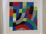 a framed picture of a colorful abstract painting on a white wall