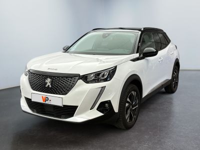 une voiture blanche garée dans une pièce au sol noir