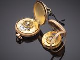 a close up of a gold pocket watch on a black surface