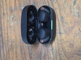 an image of a pair of black earphones sitting on a wooden table
