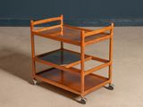 a small wooden cart with three shelves on it