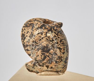 une sculpture en pierre représentant un chat assis sur un livre