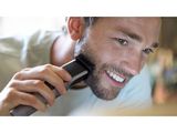 a man that is brushing his beard with a hair brush