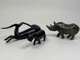 deux figurines représentant des rhinocéros et un éléphant sur un fond blanc