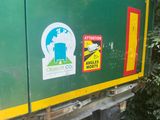 stickers on the back of a truck that is parked on the side of the road