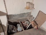 une boîte remplie de bouteilles et d'autres objets, dans un coin de la pièce