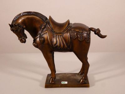 statue d'un cheval sellé, posée sur un socle, sur fond blanc
