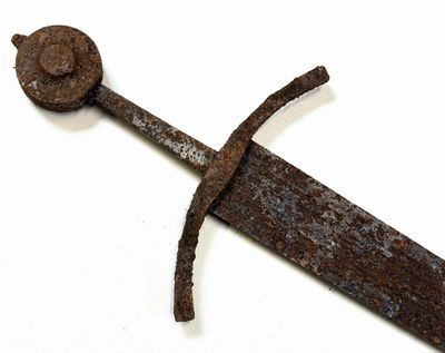 une vieille épée en fer avec une poignée en bois posée sur une surface blanche