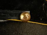 a black hat with a gold button on it