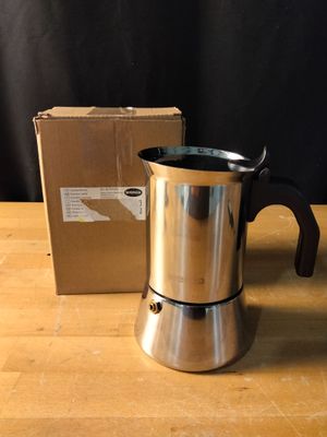 une cafetière posée sur une table à côté d'une boîte