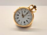 Gros plan sur une montre de poche en or avec des chiffres romains
