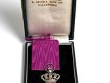 l'image d'une médaille dans un étui entouré d'un ruban