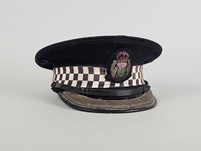 un vieux chapeau noir et blanc orné d'un écusson