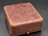 a small brown box sitting on a black surface