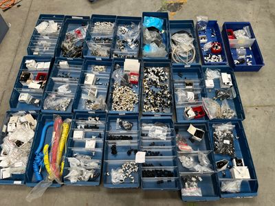de nombreux objets divers rangés dans des bacs bleus posés par terre