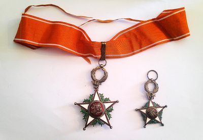 two star charms attached to a ribbon on a white surface