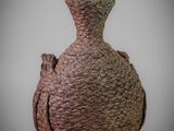 a brown vase with a green top sitting on a table