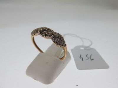 une image représentant une bague en or sertie de diamants noirs sur un fond blanc