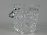 un verre en verre transparent muni d'une anse, posé sur une table