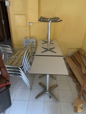 un homme debout devant une table et des chaises