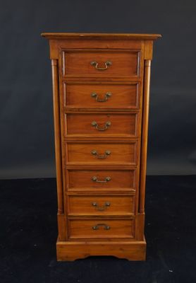 a wooden chest of drawers on a black background