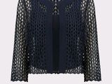 a woman is wearing a black jacket with a lace pattern