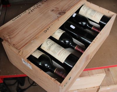 bottles of wine are in a wooden box on a table