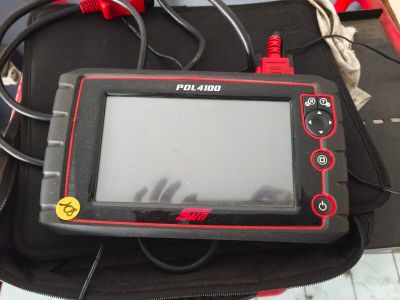 une image d'une tablette informatique noire et rouge posée sur un sac noir