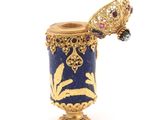 a gold and blue vase with a butterfly on it
