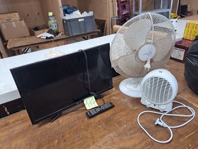 un ventilateur et un téléviseur posés sur une table dans une pièce