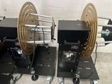 Deux bobines sont posées sur des roues dans une pièce.