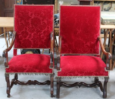 pair of red velvet upholstered chairs in an antique shop