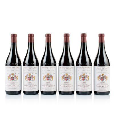 quatre bouteilles de vin sont alignées sur une surface blanche