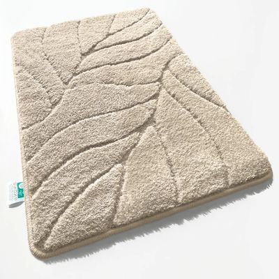 un gros plan d'un tapis de salle de bains posé sur une surface blanche