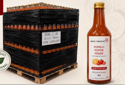 a bottle of tomato sauce next to a crate of tomatoes