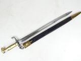 a close up of a sword on a white surface with a black handle