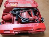 une boîte à outils rouge contenant une perceuse et d'autres outils