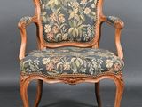 an old chair with a floral upholstered back and arms