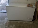 a white chest freezer sitting in the corner of a room