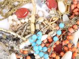 a pile of necklaces and bracelets sitting on a table