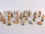 many figurines of people and animals on a white surface