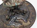 a bronze sculpture of a horse and a dog on a plate
