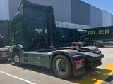 un camion vert garé devant un immeuble