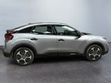 the silver car is parked on the concrete floor in the room