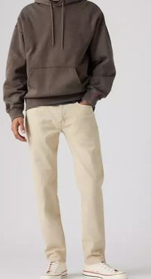 un homme vêtu d'un sweat à capuche marron et d'un pantalon kaki