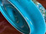 a blue bowl sitting on top of a wooden table