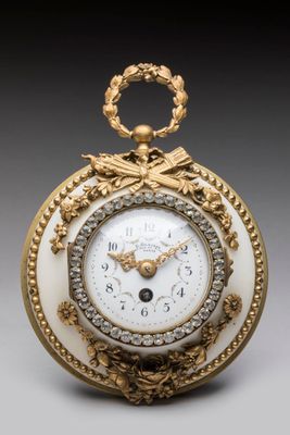 an image of a gold and white clock with a chain around the face