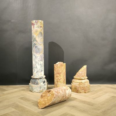 trois morceaux de marbre posés sur un parquet, près d'une colonne